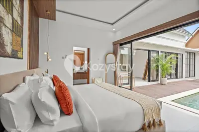 a bedroom with a white bed with orange pillows at Biyan Villa by Kozystay - Seminyak in Seminyak