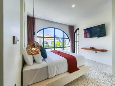 a bedroom with a large bed with a window at Villa Emilia Canggu by Nagisa Bali in Canggu