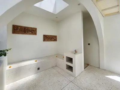 a room with a white wall with a shelf and a window at Villa Emilia Canggu by Nagisa Bali in Canggu