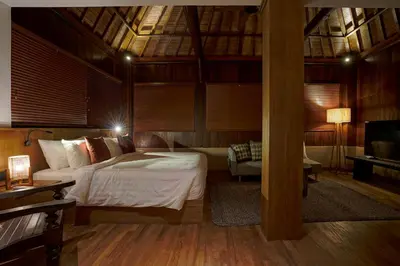 a bedroom with a bed and a couch and a television at Juan Villa Legian in Seminyak