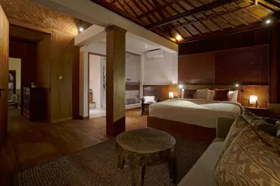 a bedroom with a bed and a table and a couch at Juan Villa Legian in Seminyak