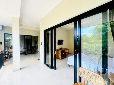 a bedroom with a view of a bed and a desk at Umah Kak Pasek in Jimbaran
