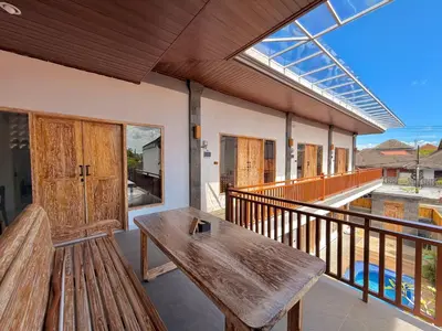 a porch with a wooden bench on a balcony at Tanhana Seminyak in Kerobokan