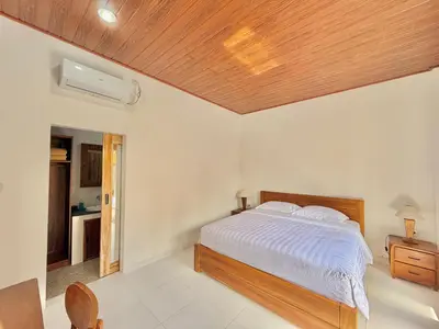 a bedroom with a bed with a wooden ceiling at Tanhana Seminyak in Kerobokan