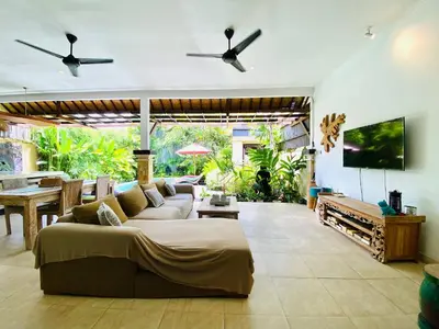 a living room with a couch and a tv at Superb Location! Modern 2BR Seminyak Oasis with Pool & Garden in Seminyak