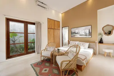 a bedroom with two beds and a table and chairs at 6BR Seminyak Oasis with 2 Private Pools in Seminyak