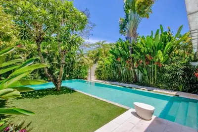 a swimming pool in a garden with trees and plants at Yelena Spacious 3 BR Private Pool Villa in Canggu