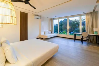 a bedroom with a large white bed and a table at Yelena Spacious 3 BR Private Pool Villa in Canggu