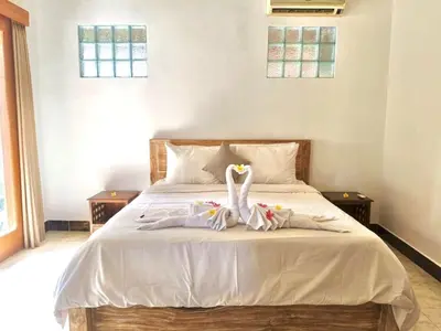 a bedroom with a bed with two swans on it at Authentic Balinese Riverside Villa in Kerobokan