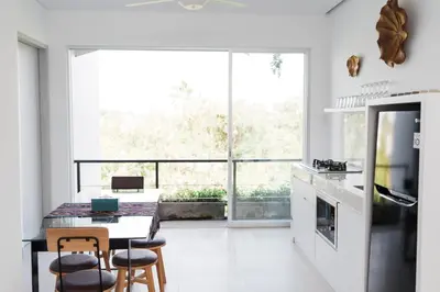 a kitchen with a table and chairs and a large window at 2 Bedroom Seminyak Apartment -1 in Seminyak