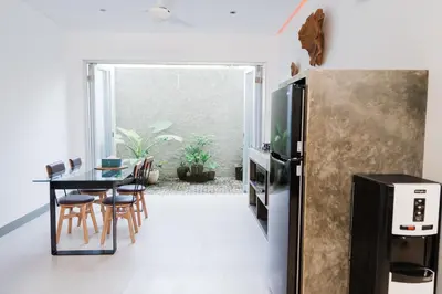 a kitchen and dining room with a table and a refrigerator at 2 Bedroom Seminyak Apartment -1 in Seminyak