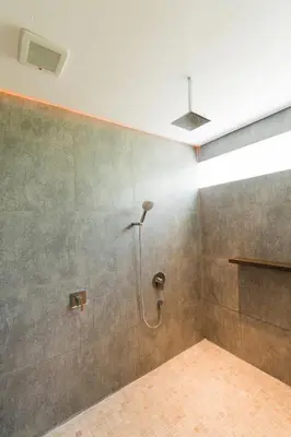 a shower in a bathroom with a tiled wall at 3 Bedroom Seminyak Apartment -3 in Seminyak