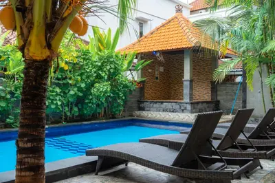 a swimming pool with chairs and a gazebo at Wana Kubu Suite and Dormitory in Ngurah Rai International Airport