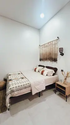 a bedroom with a large bed with white walls at Batara Room in Nusa Dua