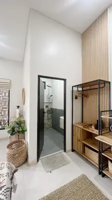 a bathroom with a glass door leading to a shower at Batara Room in Nusa Dua