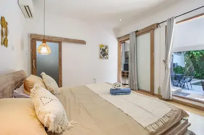 a bedroom with a large bed and a large window at Legian Beach Villa - 3-room open villa, private pool, near the beach, Netflix in Legian