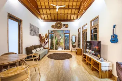 a living room with a couch and a tv at Legian Beach Villa - 3-room open villa, private pool, near the beach, Netflix in Legian