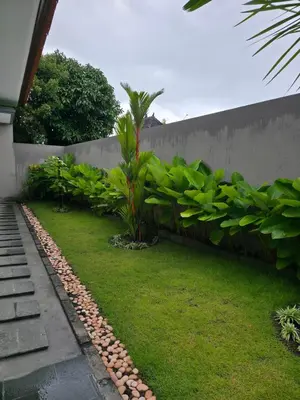 a garden with a retaining wall and plants at Le Calme Villa Brand New 2 BR Private Villa near Seminyak in Kerobokan