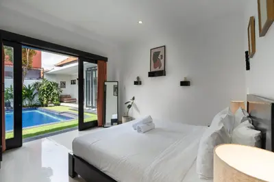 a bedroom with a bed and a swimming pool at Homy 3 Bedrooms Villas in Canggu Umalas in Kerobokan