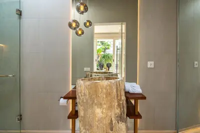 a bathroom with a wooden table and a mirror at Magic Day 2BR Private Sauna, Jacuzzi, Projector in Seminyak
