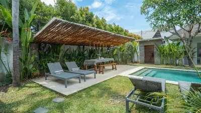 a patio with a table and chairs next to a swimming pool at Villa Alana, 3 BR Villa in Kerobokan in Mantaak