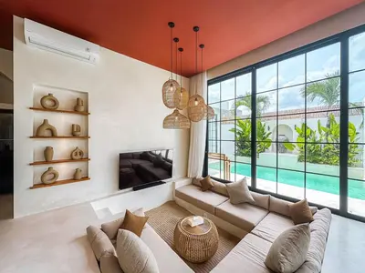 a living room with a couch and a large window at Villa Nabu - Serene Tropical Escape in Heart of Seminyak in Seminyak