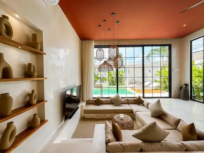a living room with a couch and a large window at Villa Nabu - Serene Tropical Escape in Heart of Seminyak in Seminyak