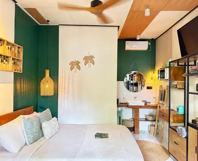 a bedroom with a bed and a green wall at Private Room, 2 Minutes walk to KuDeTa Beach Seminyak in Seminyak