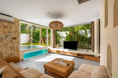 a living room with a tv and a pool at Villa Twin 1 by BaliSuperHost in Seminyak