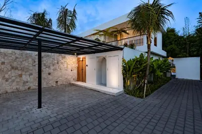 a building with awning next to a palm tree at Villa Twin 1 by BaliSuperHost in Seminyak