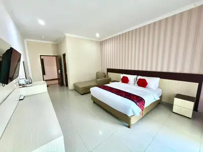 a hotel room with a bed and a television at Famora Stay Kuta Bali in Ngurah Rai International Airport