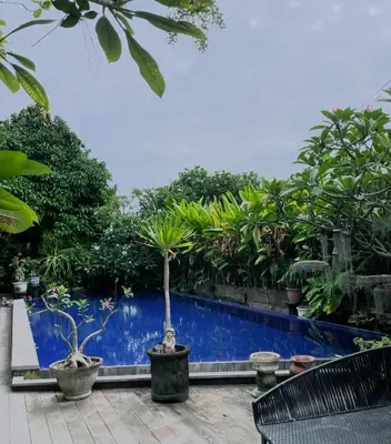 a garden with a blue fence and plants at ET Living Cozy Studio Room in Kerobokan