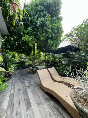 a couch sitting on a wooden deck with an umbrella at ET Living Cozy Studio Room in Kerobokan