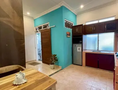 a kitchen with a table and a blue wall at Digital Nomad Oasis in Bali Calm, Cozy, Connected in Kerobokan