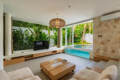 a living room with a tv and a swimming pool at Villa Twin 2 by BaliSuperHost in Canggu