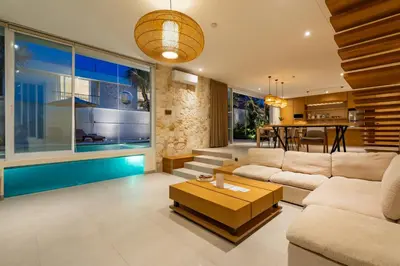 a living room with a couch and a swimming pool at Villa Twin 2 by BaliSuperHost in Canggu