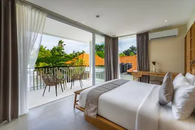 a bedroom with a bed and a balcony with a view at Villa Twin 2 by BaliSuperHost in Canggu