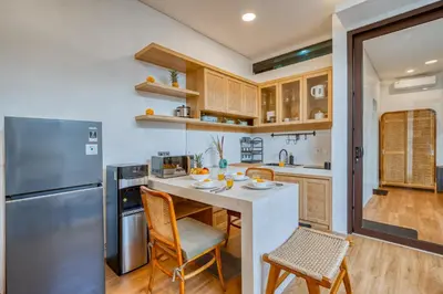 a kitchen with a refrigerator and a table and chairs at Affordable 2 Bedroom Villa in Kerobokan with Private Pool in Kerobokan