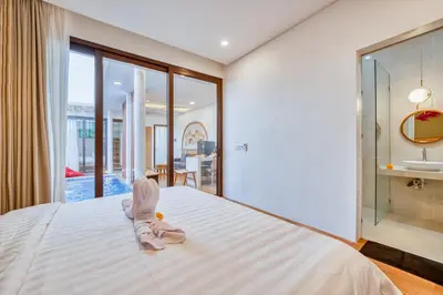 a bedroom with a large white bed and a sink at Affordable 2 Bedroom Villa in Kerobokan with Private Pool in Kerobokan