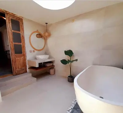 a bathroom with a bath tub and a sink at Joglo Raera Bali by Allura in Seminyak