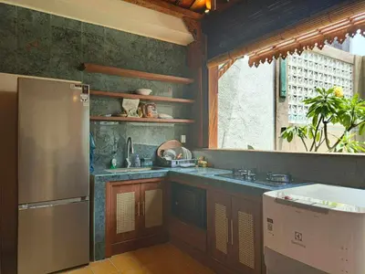 a kitchen with a stainless steel refrigerator and a sink at Joglo Raera Bali in Seminyak