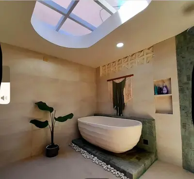 a bathroom with a large bath tub and a skylight at Joglo Raera Bali in Seminyak