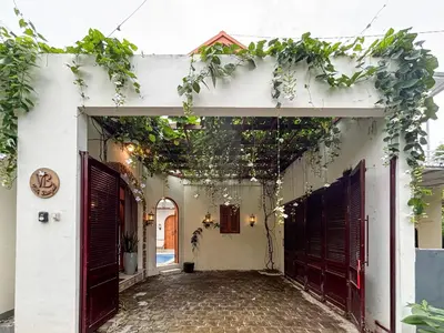 an entrance to a white house with plants on the ceiling at The Lavana Villa Bungas near Nusa Dua in Jimbaran