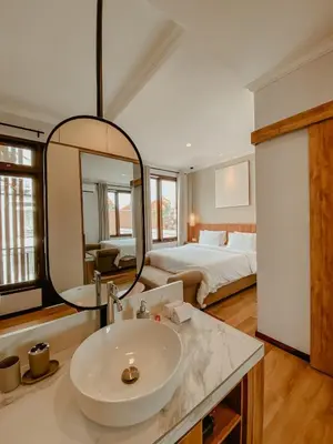 a bathroom with a sink and a bedroom with a bed at The Maru House in Seminyak