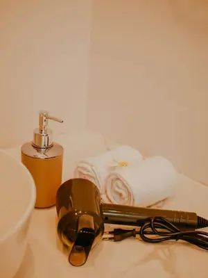 a bathroom counter with a towel and a hair dryer and glasses at The Maru House in Seminyak