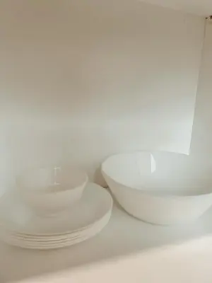 two white bowls and plates sitting on a shelf at The Maru House in Seminyak