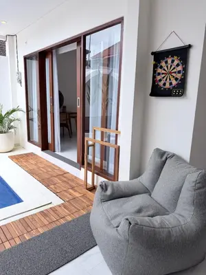 a living room with a chair and a clock on the wall at Villa Amore in Canggu