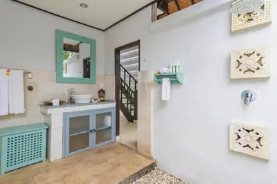 a bathroom with a sink and a mirror at Calinda Tropical 1 BR Bungalow With Garden View in Seminyak