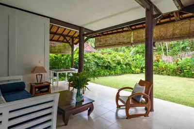 a living room with a couch and a table at Calinda Tropical 1 BR Bungalow With Garden View in Seminyak
