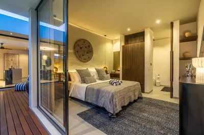 a bedroom with a large bed and a glass wall at Villa Knack, Seminyak in Kerobokan